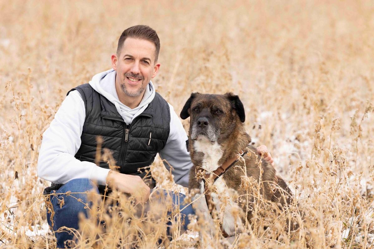 Hundesitter mit Hund im verschneiten Feld